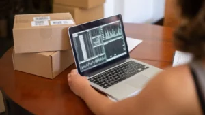 Persona revisando gráficas en un portátil en la mesa de su negocio